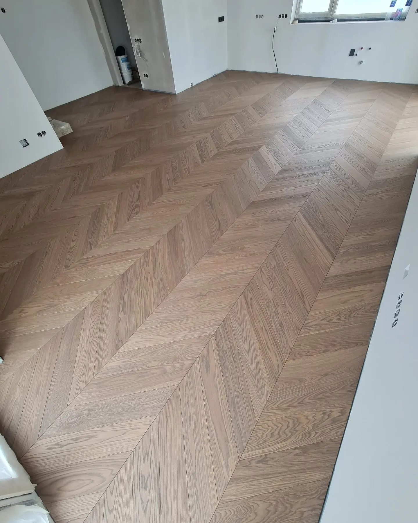 Oak engineered boards in a room with a glass wall, a band of sunlight across the floor