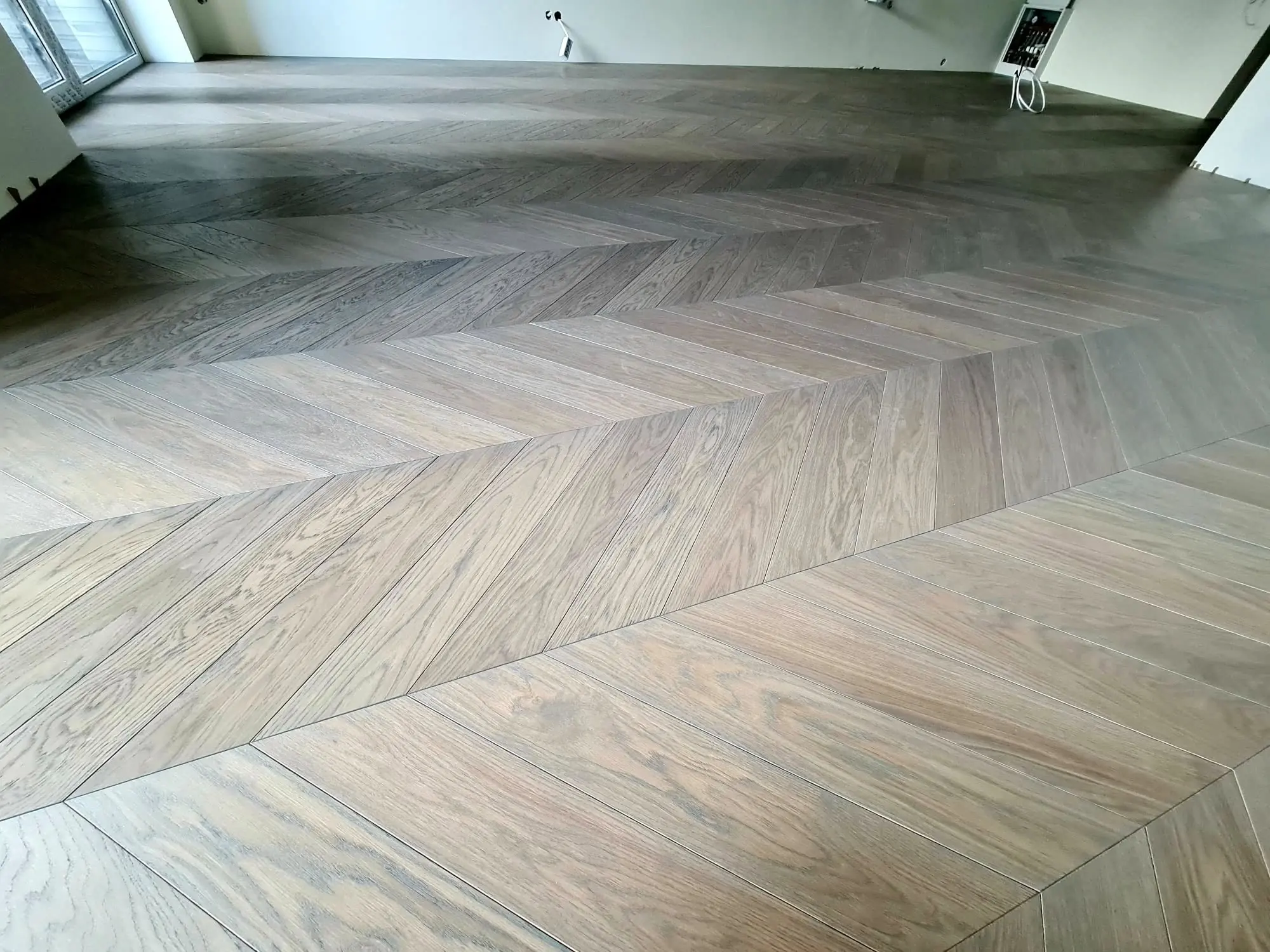 Chevron running the full width of a room, boards meeting in one unbroken V