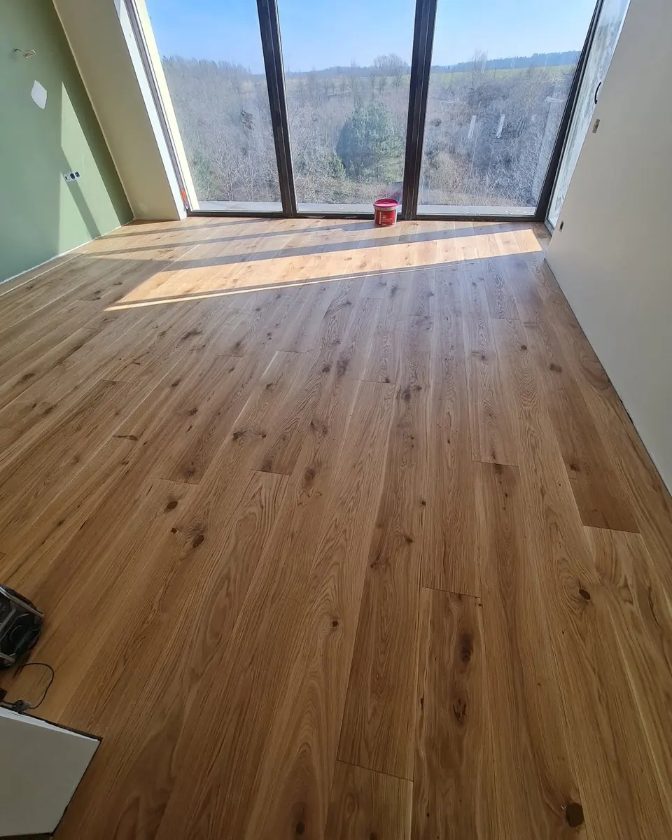 Oak floor in a room with a panoramic window onto woodland