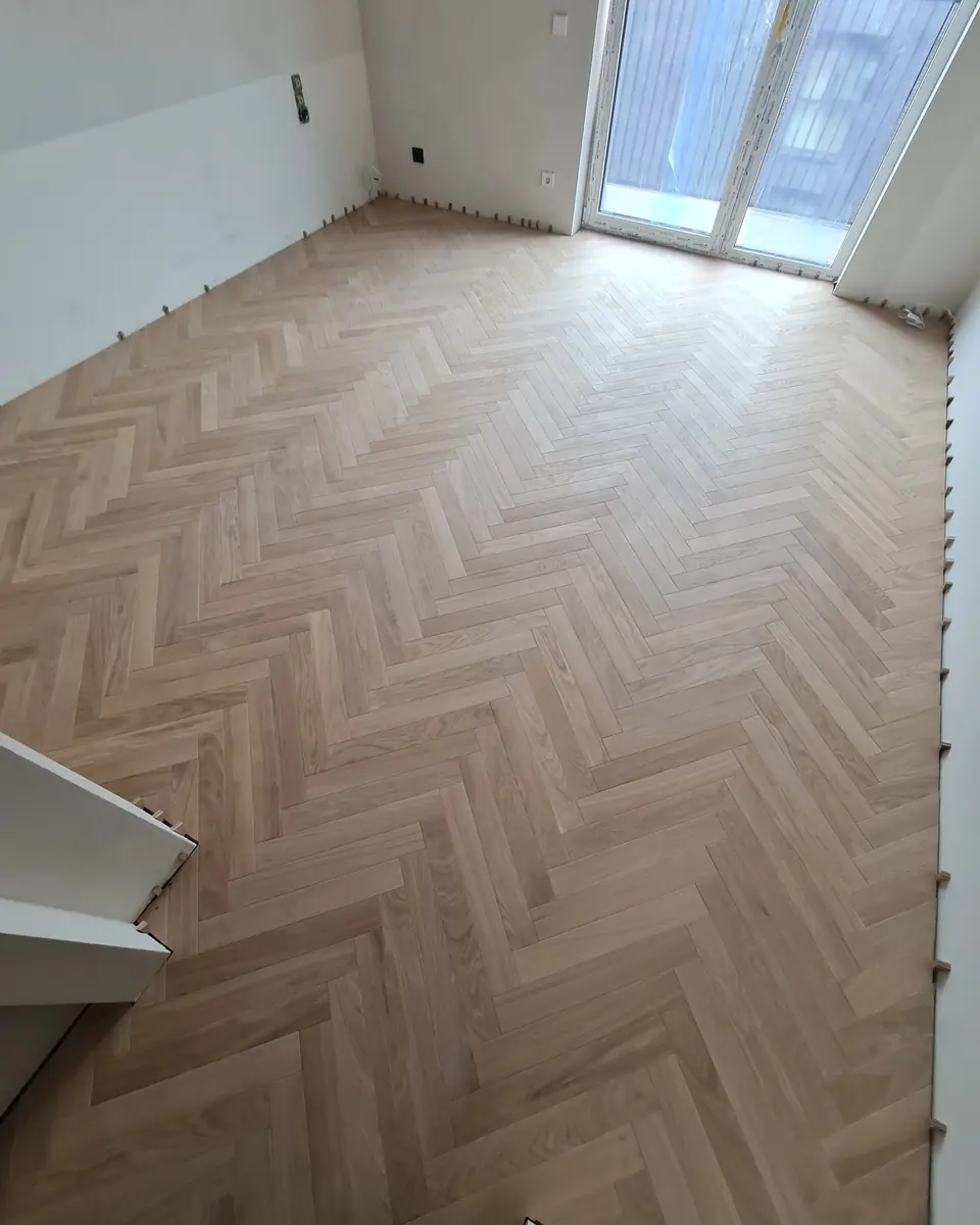 Pale oak classic herringbone in a room with glazed doors onto the balcony